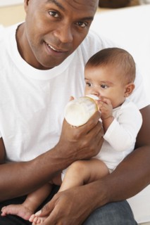 African father feeding baby daughter