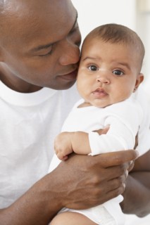 African father hugging baby daughter