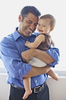 Hispanic father holding daughter