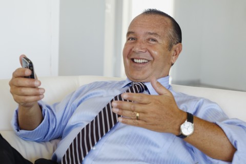 Hispanic businessman holding cell phone