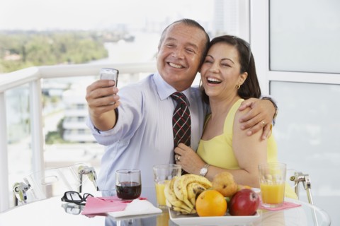 Hispanic couple taking self-portrait with cell phone