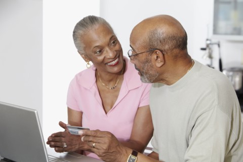 African couple shopping on internet with credit card