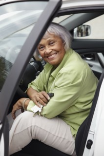 Senior African American woman sitting in driver's seat of car