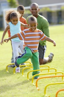 African American boy running across obstacle course