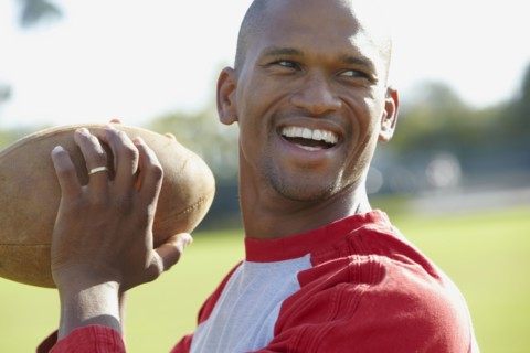 African American man throwing football