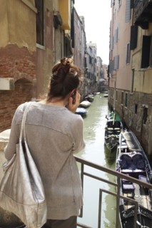 Italian woman talking on cell phone near canal