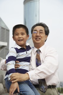 Chinese grandfather and grandson sitting together outdoors