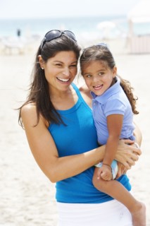 Hispanic mother and daughter enjoying beach