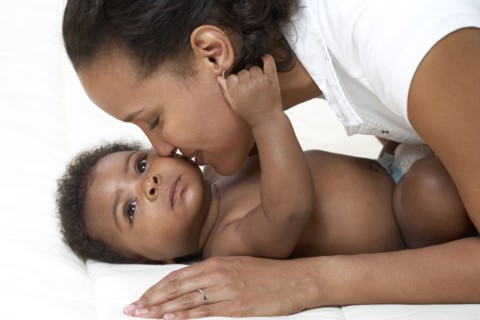 African American mother kissing baby
