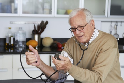 Caucasian man taking his own blood pressure