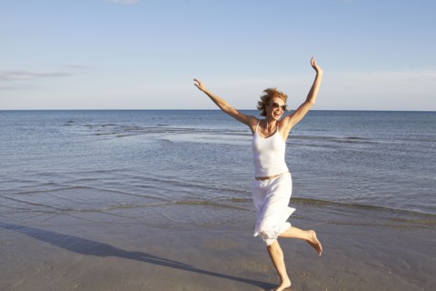 Caucasian woman playing on beach