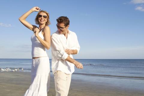 Caucasian couple dancing on beach
