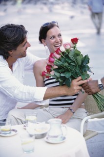 Man buying flowers for girlfriend at sidewalk cafe
