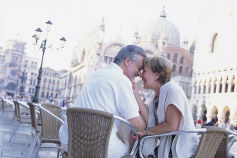 Senior couple touching foreheads at sidewalk cafe