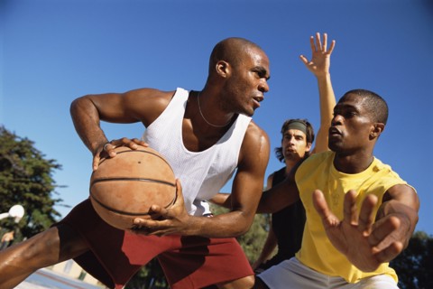 Men playing basketball outdoors