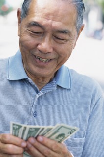 Senior man counting money outdoors