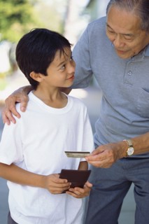 Senior man giving grandson credit card