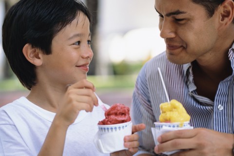Father and son eating ice cream outdoors