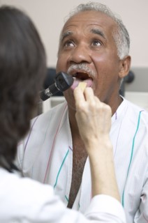 Doctor checking Senior man's tongue