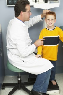 Doctor measuring boy's height in office
