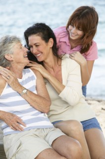 Three generations of women smiling outdoors