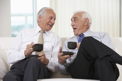 Senior businessmen having coffee on sofa