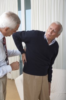 Senior man seeing doctor about back pain