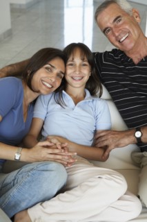 Hispanic family smiling together on sofa