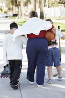 Mother and children walking on suburban street