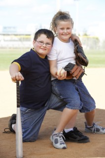 Children smiling together on baseball diamond