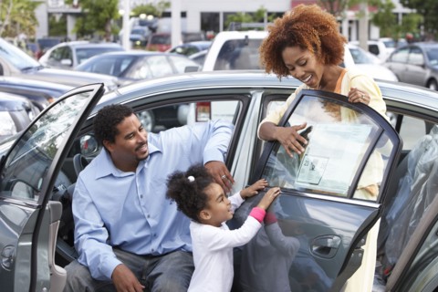 Black family admiring new car