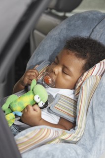Black baby sleeping in car seat