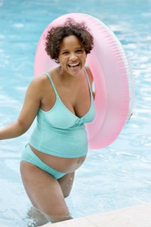Pregnant woman cheering in swimming pool