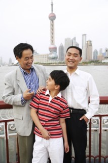 Three generations of men smiling by city skyline
