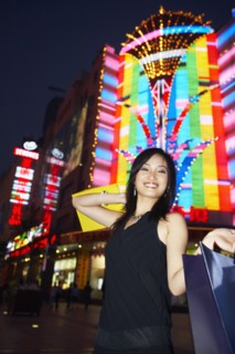 Smiling woman on city street lit up at night