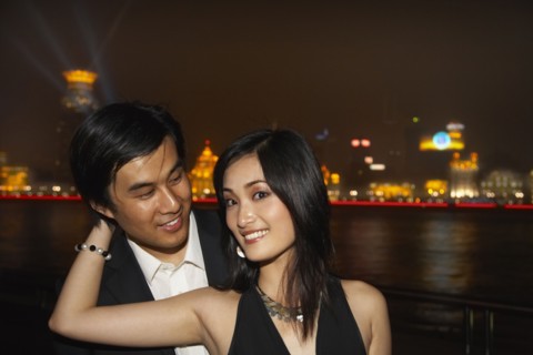 Couple by city skyline lit up at night