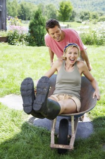 Man pushing girlfriend in wheelbarrow