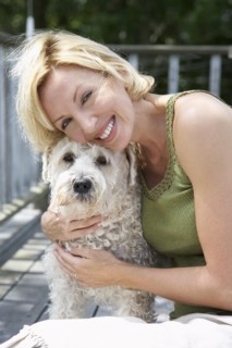 Woman petting dog on wooden patio