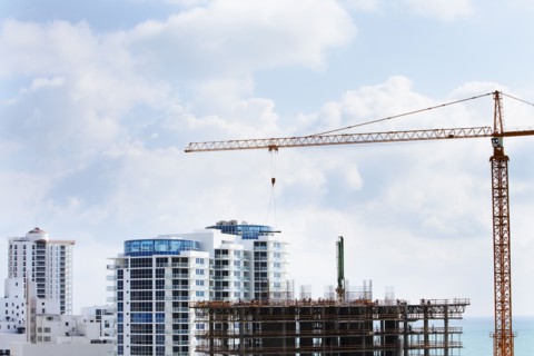 Crane extending over urban construction site