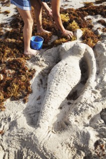 Mermaid sculpture in sand on beach