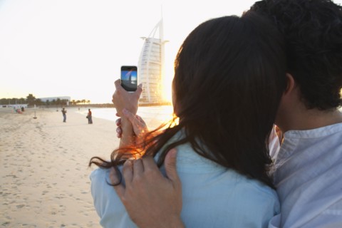 Couple taking pictures together on beach