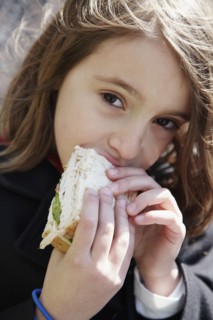 Girl eating sandwich outdoors