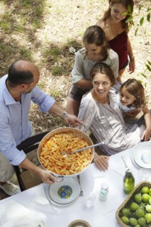 Family eating together at table outdoors
