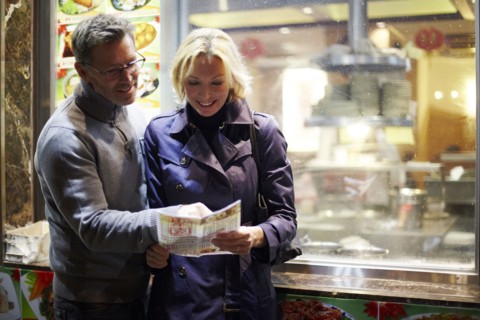 Caucasian couple reading menu at food cart