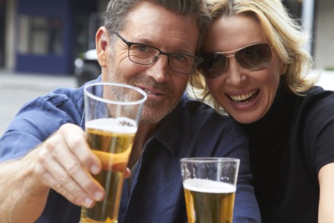 Caucasian couple drinking beer outdoors