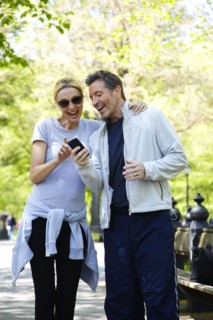Caucasian couple using cell phone in park