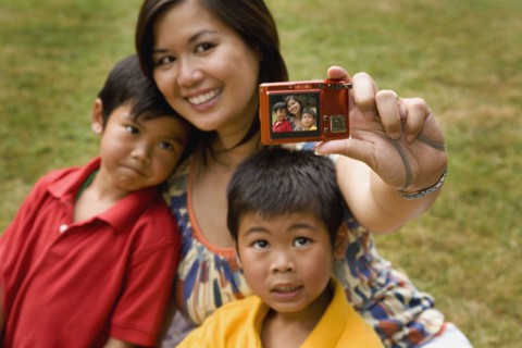 Asian mother and sons taking self-portrait