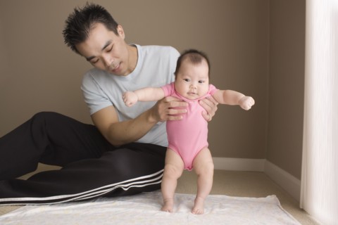 Chinese father helping daughter to learn to walk