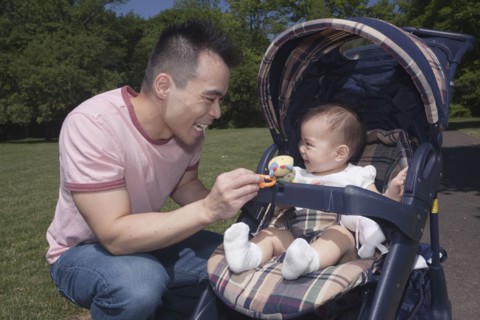 Chinese father and baby in stroller at park