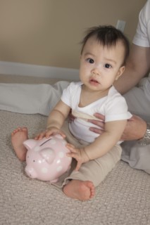 Chinese father and baby with piggy bank